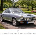 BMW Glas 1600, Kalenderblatt für Juli; silberner Oldtimer, parkähnliche Umgebung mit Rasen und Bäumen im Hintergrund.