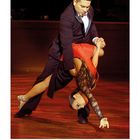 Kalender mit Juli-Daten unten. Tanzpaar in dynamischer Pose: Mann im Anzug, Frau im roten Kleid.