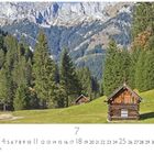 "Im Tannheimer Tal" und "CASARES EDITION". Hütten in einer grünen Wiese mit Nadelbäumen und Bergen im Hintergrund.