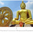 Zahlen 1-31 unten, 7 groß in der Mitte. Goldene Buddha-Statue und reich verziertes Rad vor blauem Himmel.