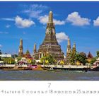 Bangkok Wat Arun. Der Tempel ragt majestätisch gegen den blauen Himmel, umgeben von Wasser und grünen Bäumen.