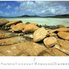 "Whitehaven Beach" unten links. Gelb-braune Felsen im Vordergrund, weißer Sandstrand, blau-grünes Wasser, bewölkter Himmel.