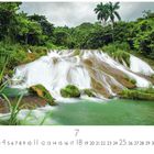 El Nicho Wasserfall. Kalenderblatt für den Monat Juli. Ein Wasserfall fließt über Felsen, umgeben von üppigem Grün.