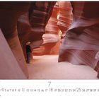 "Antelope Canyon Arizona". Ein Mann mit Hut steht in einer beeindruckenden, wellenförmigen Schlucht mit orangefarbenen Wänden.