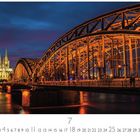 Text: "Köln Deutzer Brücke". Abgebildet ist eine beleuchtete Brücke bei Nacht mit einem Dom im Hintergrund.