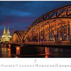 „Deutzer Brücke“ steht unten. Eine beleuchtete Brücke vor einem beleuchteten Gebäude bei Nacht. Kalendarium darunter.