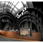 Text: "NANA COFFEE ROASTERS, Bangkok, Thailand." Innenraum mit gewölbtem Design, Tresen, Stühlen, und einer Glasvitrine.
