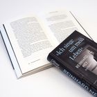 Text: „Ich singe um mein Leben“ Reinhard Mey. Aufgeschlagenes Buch auf dem Tisch. Schwarz-weißes Foto auf dem Buchdeckel.