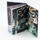 Illustration auf einem aufgeklappten Buch, zeigt Figuren in traditioneller Kleidung mit blühenden Zweigen im Hintergrund.