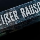 "Weißer Rausch" in großen, weißen Buchstaben auf einer gefrorenen, eisigen Oberfläche.