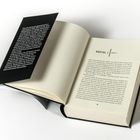 Kapitel 1: Puffy. Buch zeigt ein aufgeschlagenes Kapitel. Schwarzer Einband mit Text auf linker Innenseite.