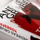 Text: "ANDREAS GRUBER TODESFÄLLE" in großen Buchstaben. Das Cover ist rot mit dunklen Schatten.