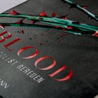„BLOOD, DU SOLLST BEREUEN.“ Darunter „GOLDMANN.“ Ein blutiger Dornenzweig auf einem dunklen Hintergrund.