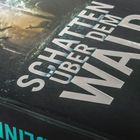 Text: "SCHATTEN ÜBER DEM WALD" und "Kriminalroman". Eine dunkle, mysteriöse Abbildung mit einem roten btb-Logo.