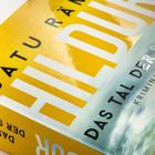 Cover mit gelbem Hintergrund. Text: "SATU RÄMÖ, HILDUR, DAS TAL DER SCHULD, KRIMINALROMAN". Eine Landschaft darunter.