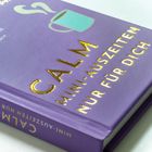 Der lila Buchumschlag zeigt goldene Schrift: "CALM MINI-AUSZEITEN NUR FÜR DICH", darüber eine Tasse mit Dampf.