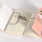 "7 HOW TO FIX TRAVEL" auf einer Buchseite. Daneben liegt eine Broschüre mit Bild und Text über Philip Laage.