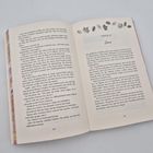 Kapitel 27: Zane. Das Buch ist offen und der Text ist in zwei Spalten auf zwei Seiten gedruckt. Oben sind Blätter abgebildet.