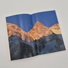 Kein Text erkennbar. Ein Foto von zwei schneebedeckten Bergen im Sonnenlicht, vor einem tiefblauen Himmel in einer offenen Zeitschrift.