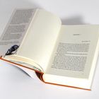 Text: KAPITEL 1. Bad Godesberg, 2023. Ein offenes Buch mit orangefarbenem Einband und einer Blume auf dem Umschlag.