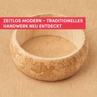 "Zeitlos modern – traditionelles Handwerk neu entdeckt." Ein Holzbogen mit eingravierten Blättern.