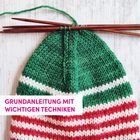 "GRUNDANLEITUNG MIT WICHTIGEN TECHNIKEN." Strickprojekt mit grünen, weißen und roten Streifen; Stricknadeln oben.