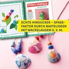 ECHTE HINGUCKER – SPASSFAKTOR DURCH BASTELIDEEN MIT WACKELAUGEN U. V. M. Bunte Muscheln mit Perlen auf rosa Hintergrund.