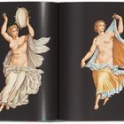 Zwei tanzende Frauen in fließenden Gewändern: links mit Tamburin, rechts die Hand erhoben, auf schwarzem Hintergrund.