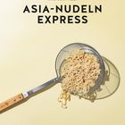 Text: "ASIA-NUDELN EXPRESS, ANNE-KATRIN WEBER". Ein Sieb mit Asia-Nudeln auf hellem Hintergrund. Fotografie von Wolfgang Schardt.