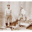 Zwei Männer stehen in einem Boot auf einem Fluss. Der eine trägt eine Kappe. Sepiatonaufnahme.