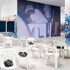 Texte: "CUBA", "VIDA", "AMORE", "ION NOLINO". Viele weiße Stühle, bunte Graffiti-Wände, übergroßes Foto einer schlafenden Person.