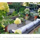 Kalenderblatt Juli: Bild eines Gartens mit blühenden Hortensien, einer langen Bank, einem Tisch und Pflanzen in Töpfen.