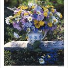 Kalenderblatt für Juli 2027 mit einem Blumenstrauß aus gelben, weißen und violetten Blumen in einer Kanne.