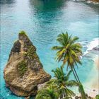 Kalenderblatt: Juli 2021. Türkisblaues Meer, steile Felsen, Palmen am Ufer, sanfte Wellen treffen auf den Strand.