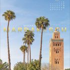 "Juli" in Kalenderform, "MAROKKO", "MARRAKESCH"; Palmen, klarer Himmel, historische Turmstruktur.
