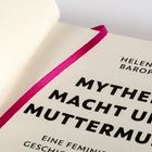 Helena Barop, Mythen, Macht und Muttermund, eine feministische Geschichtsschreibung. Ein aufgeschlagenes Buch mit rosa Band.