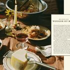 Bei Sauce gilt: Weniger ist mehr. Ein gedeckter Tisch mit Pasta, Käse, einer Kerze, Wein und einer Blume in der Vase.