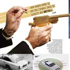 Text: „Wir haben Farbe so auf Holz gemalt, dass sie glänzte wie Metall“ - Ken Adam. Hände halten eine goldene Pistole. Unten ein Aston Martin.