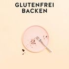 Text: „GLUTENFREI BACKEN“. Ein leerer, rosafarbener Teller mit Kuchenkrümeln und einer Gabel auf beigem Hintergrund.