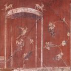 Zahlen 1 bis 31 unten. 
Rote Wandmalerei mit Reben, Vögeln und Ziegen um eine Nische.