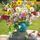 Kalender für Juli 2027. Ein bunter Blumenstrauß in einer blauen Vase auf einem Steinblock, umgeben von Äpfeln.