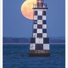 Kalenderblatt für Juli 2027 zeigt einen schwarz-weiß karierten Leuchtturm mit riesigem Vollmond im Hintergrund über dem Meer.