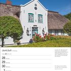 Juni/Juli, 26. Woche, 21.6.–22.7. Zitat: "Ein Haus ist eine Arche..." Ein weißes Friesenhaus mit Reetdach und Garten.