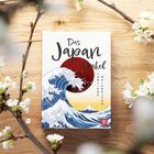 "Das Japan Orakel. Tägliche Weisheiten." Illustration: Große Welle mit roter Sonne im Hintergrund, umgeben von weißen Blüten.