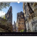"Juli" und Tagesangaben. Hohe, schroffe Felsen, strahlend blauer Himmel, oben Baumzweige. Felsenschlucht im Sonnenlicht.