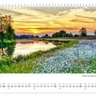 Kalenderblatt Juli, darunter Monatsübersicht. Foto zeigt Sonnenuntergang über Fluss und Blumenwiese.