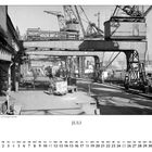 Text: "JULI". Ein Schwarz-Weiß-Foto eines geschäftigen Hafenbereichs mit Kränen und Arbeitern. Ein Mann zieht einen Karren.