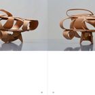 „Untitled, 2025“ steht unten links. In der Mitte sind zwei abstrakte Holzskulpturen mit geschwungenen Formen.