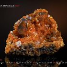 "MUNDUS MINERALIS 2027", "JULI", "Mimetesit auf Goethit", orange-brauner Mineralbrocken mit kristallinen Strukturen.