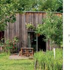 "Von der Brückenklasse zum Lebensraum. Freie Waldorfschule Berlin." Ein Holzhäuschen mit Rosen, Tisch und Stuhl im Garten.